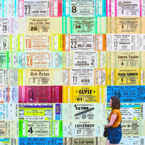 customer in front of wall of concert tickets.jpg