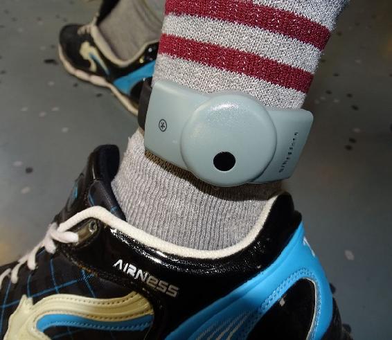 a photograph of an electronic monitoring bracelet around the ankle of a delinquent. 
