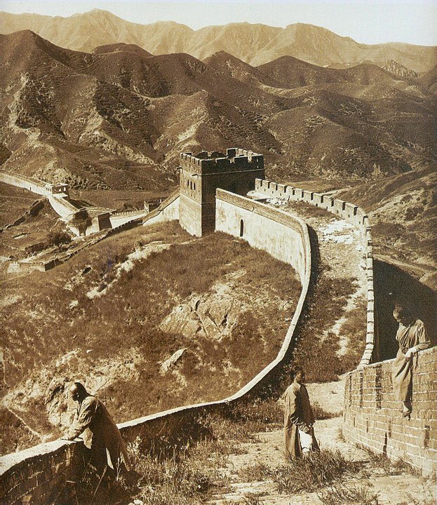La Grande Muraille de Chine avec trois personnes assises et debout vers 1907