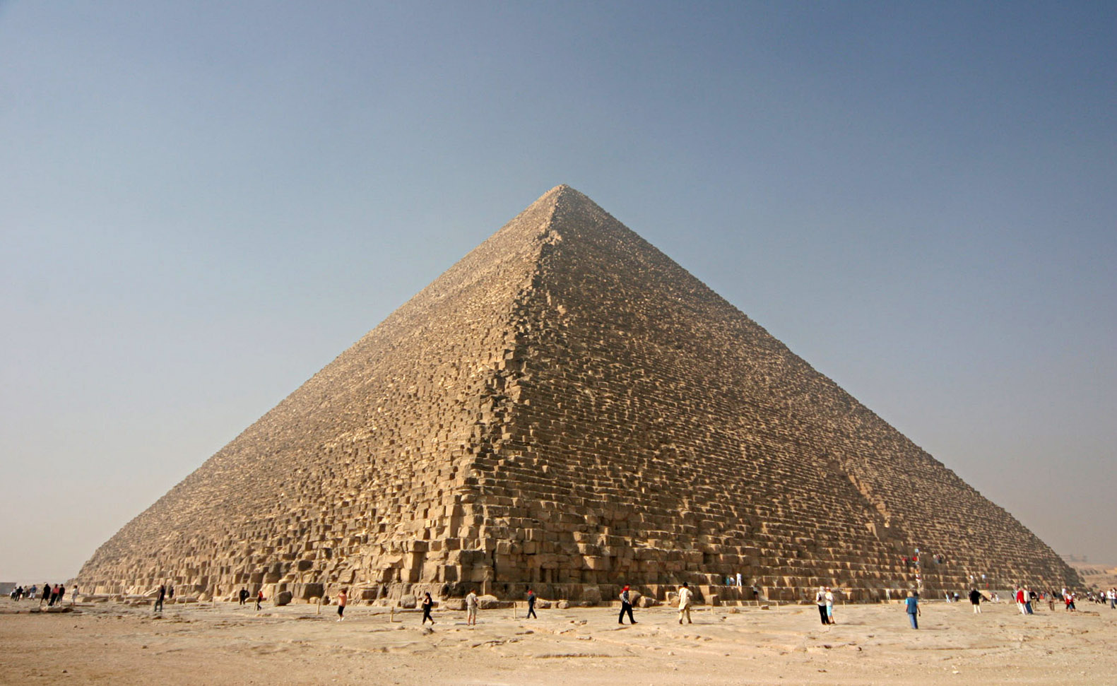 Tourist walking around the base of the Great Pyramid of Giza