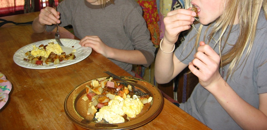 people sitting a table eating a home-cooked breakfast