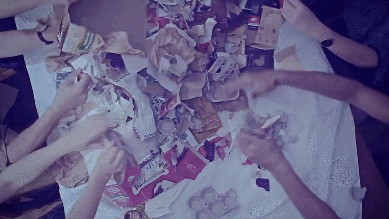 animated GIF of many hands tearing up food packaging waste