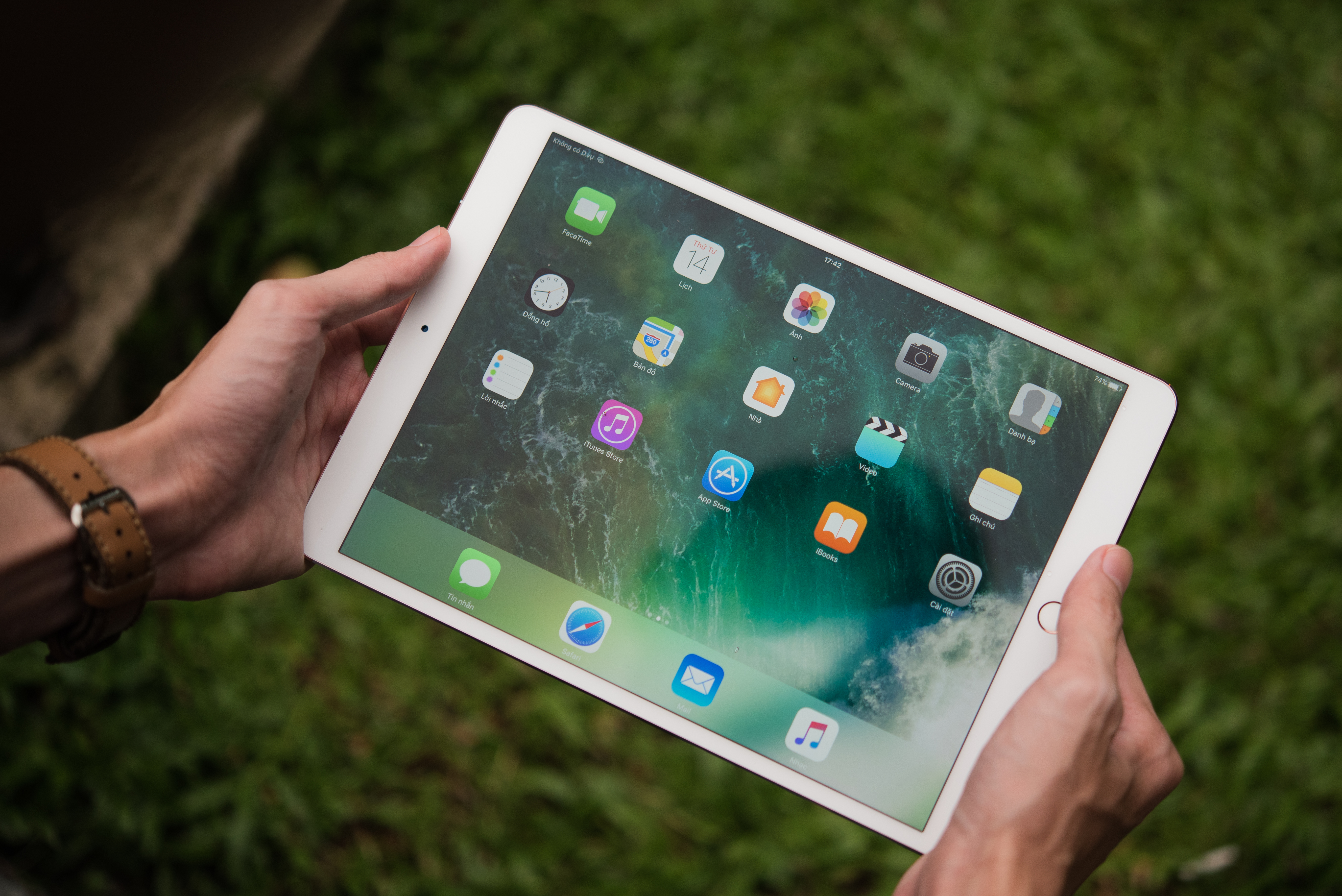 A photograph shows a person holding an iPad pro. There are colorful widgets and apps on the screen.