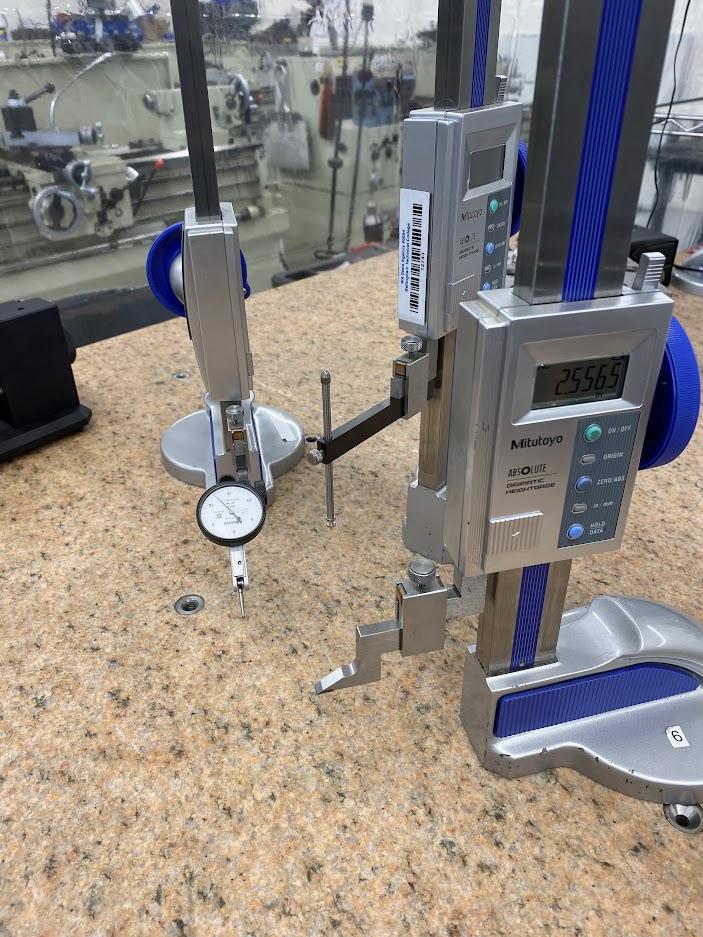 Three height gages on a surface plate with a scribe attachment, dial indicator and a drop gage attachment.