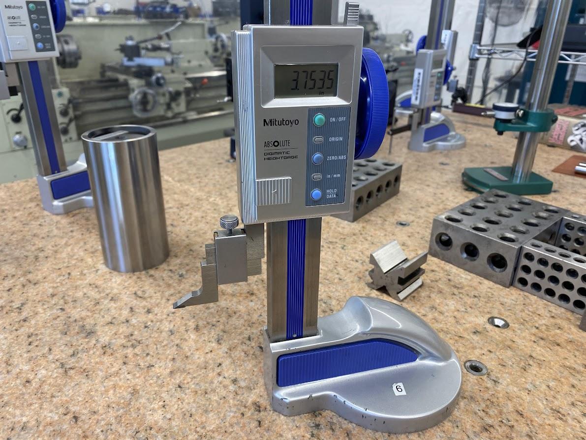 A height gage sitting on a surface plate with a scribe attachment installed.