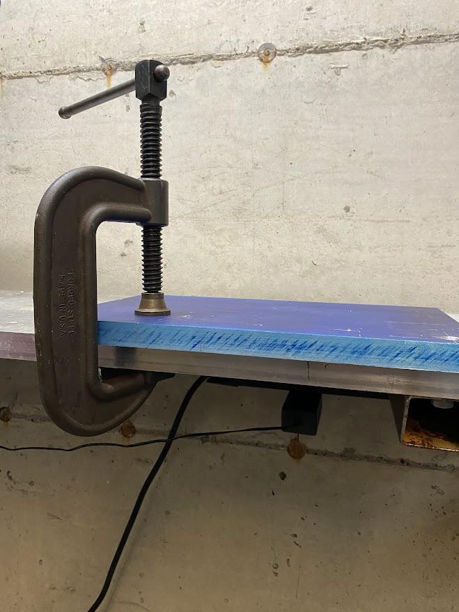 A C-clamp holding a workpiece in place for machining operations.