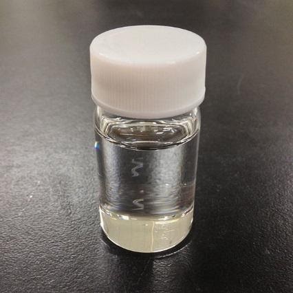 A photograph of a sample bottle with a clear fluid inside of it.