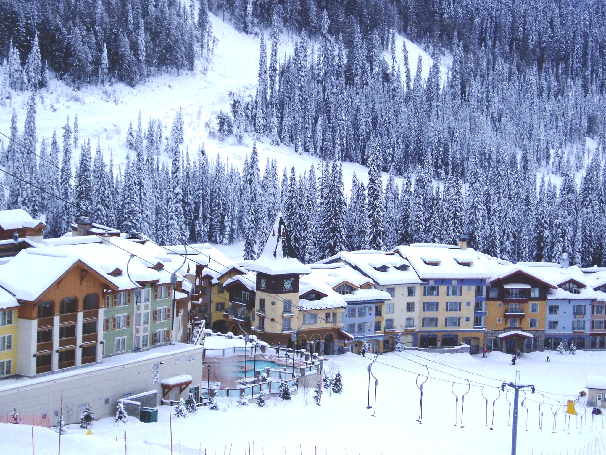 Un gran hotel en la parte inferior de una colina de esquí en invierno.
