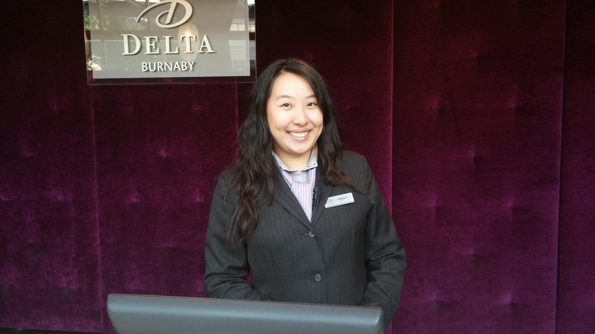 A female front desk employee smiles.