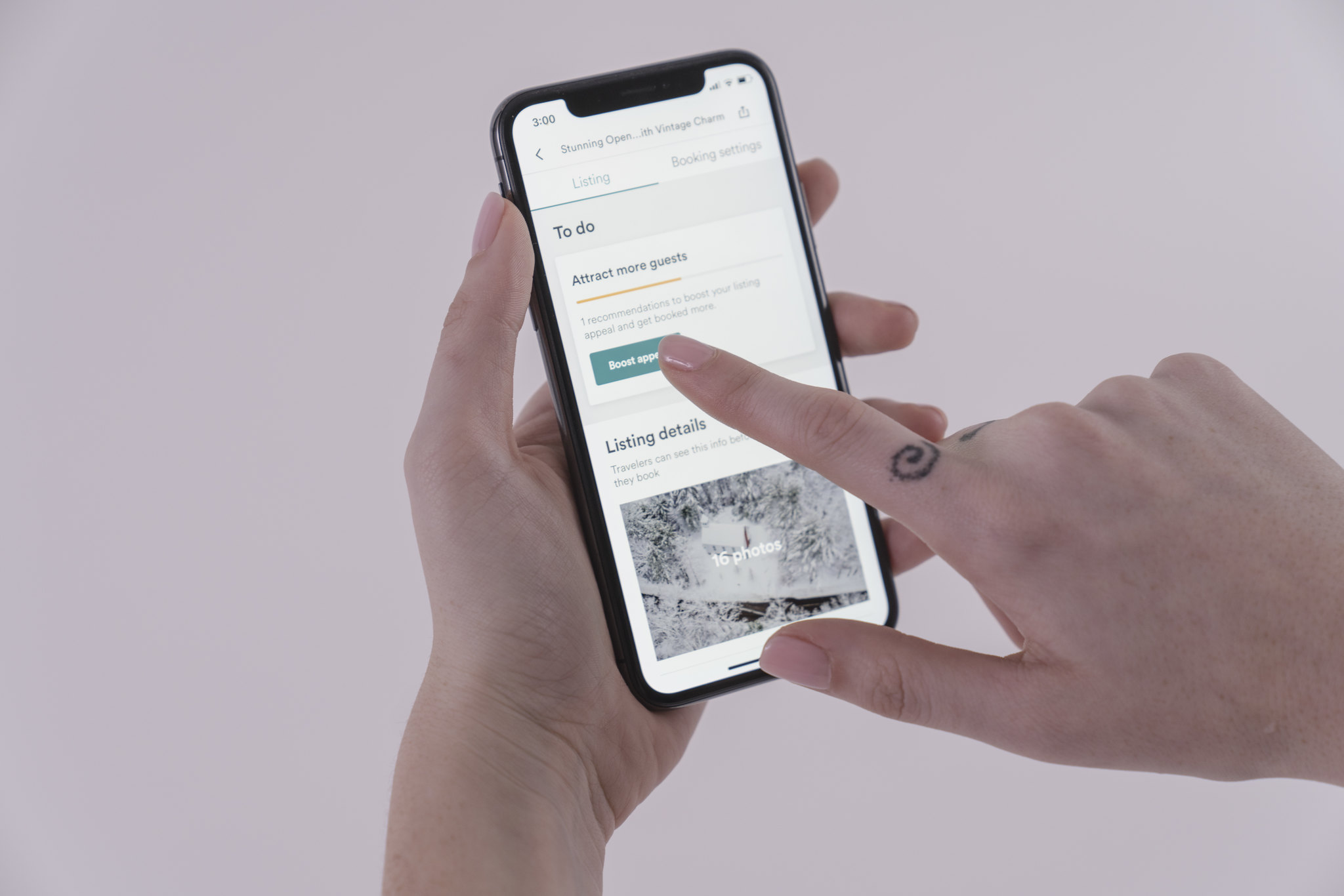 Hands hold a smartphone with the Airbnb app open.