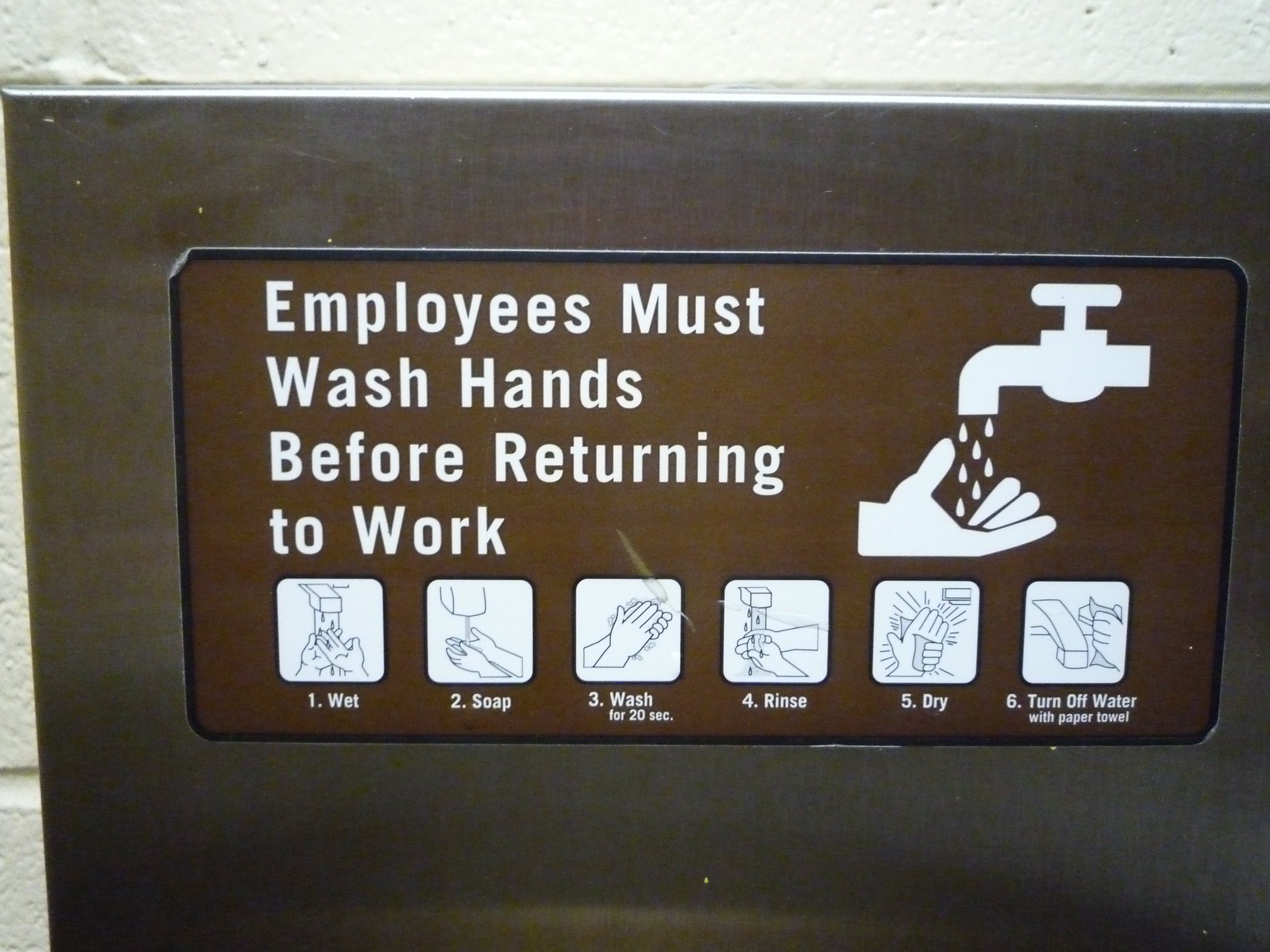 Un letrero que describe el lavado adecuado de las manos, desde mojar las manos hasta apagar el agua.