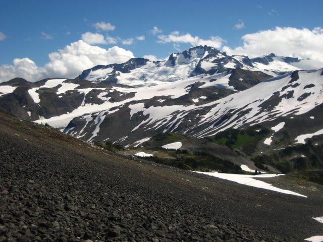 Una gran montaña con roca desnuda que se muestra a través de la nieve.