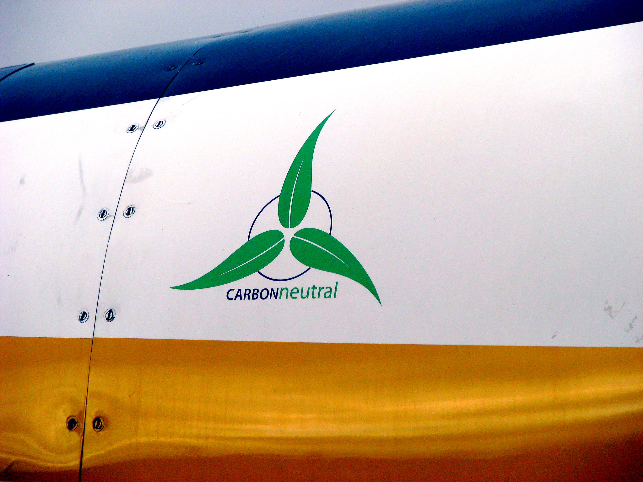 A symbol saying "carbon neutral" on the side of a sea plane.