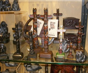 Small mass-produced totem poles on a shop shelf.